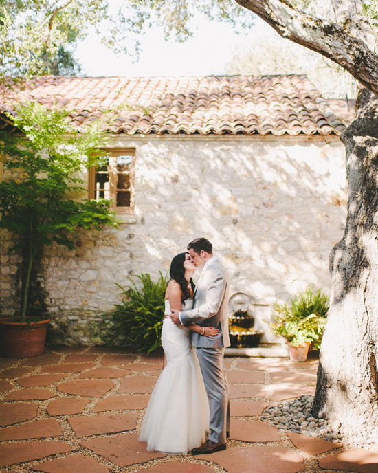 Bride and groom kissing at outdoor wedding venue
