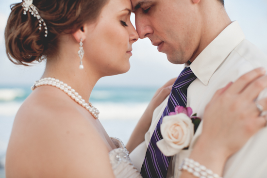 Bride and groom forehead to forehead at beach wedding