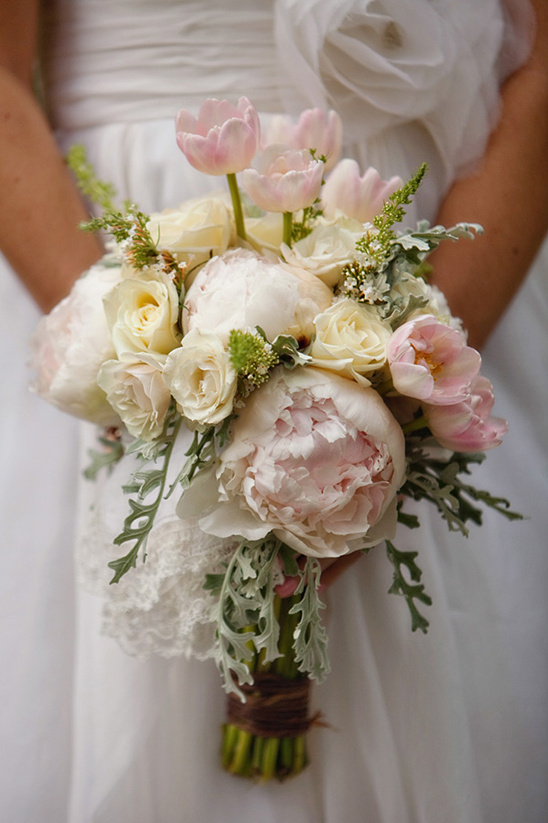 Bridal bouquet of tulips peonies and roses held close