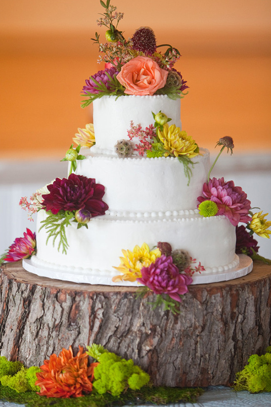 Floral wedding cake on rustic wood stand
