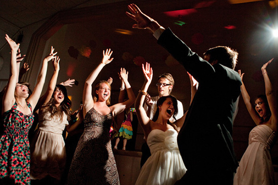 Energetic wedding guests joyfully dancing at reception