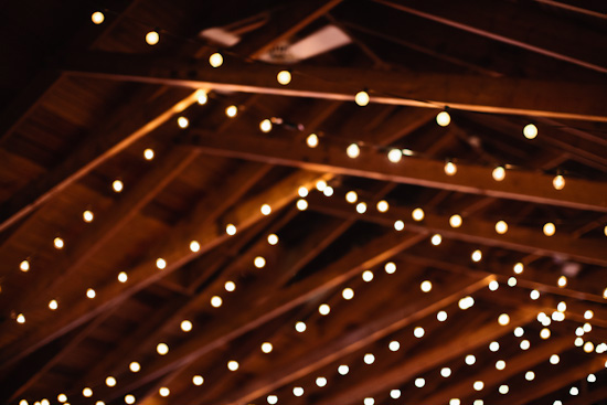 Warm string lights on a wood beamed ceiling blur