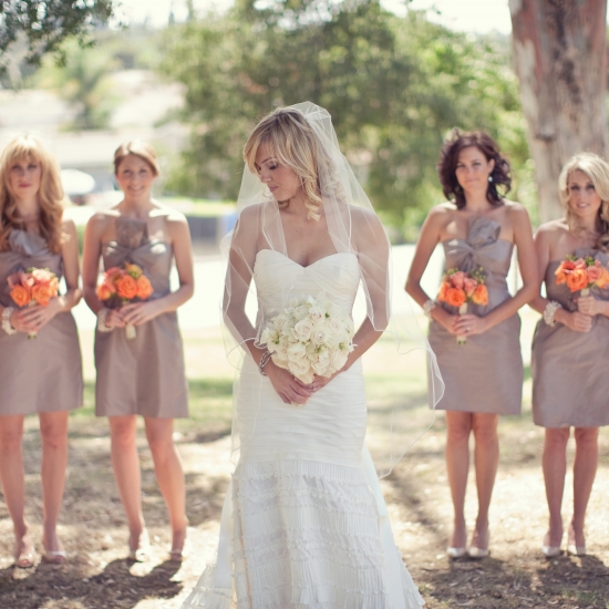 Bride in white gown with bridesmaids in taupe