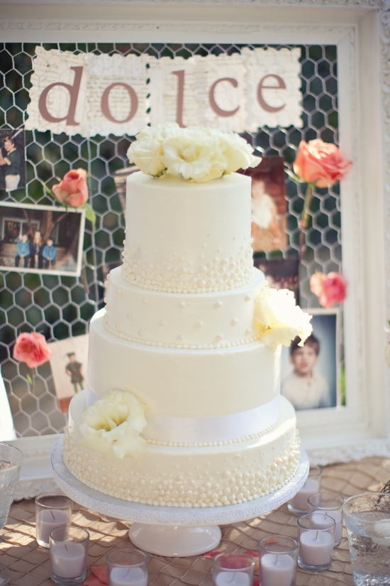 Elegant four-tiered wedding cake with pearl accents
