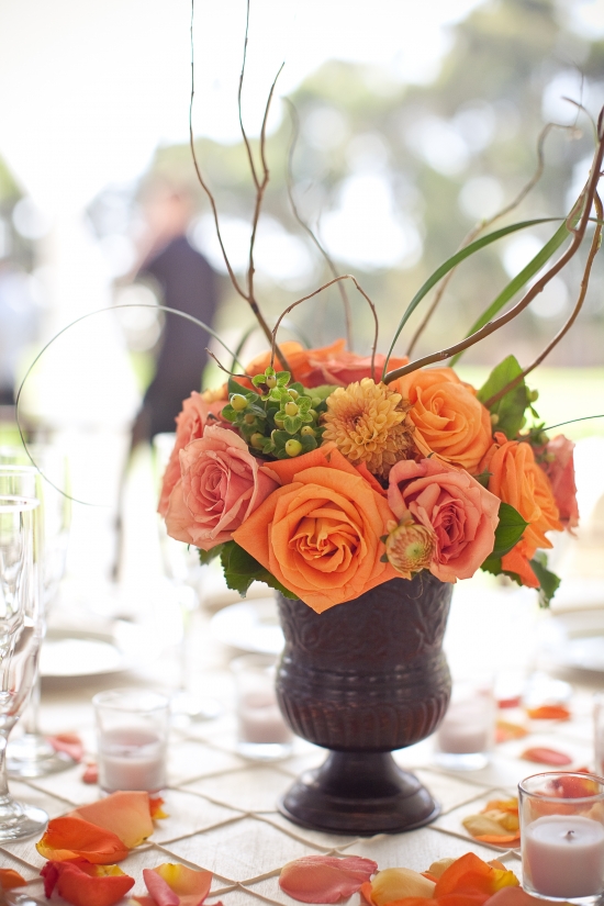 Orange rose centerpiece in dark vase at wedding reception