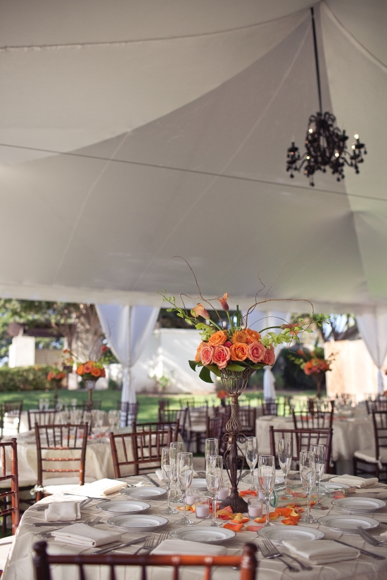 Wedding reception centerpiece: orange roses in elegant vase