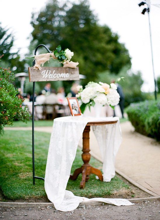 Wedding welcome sign with flowers and draped table