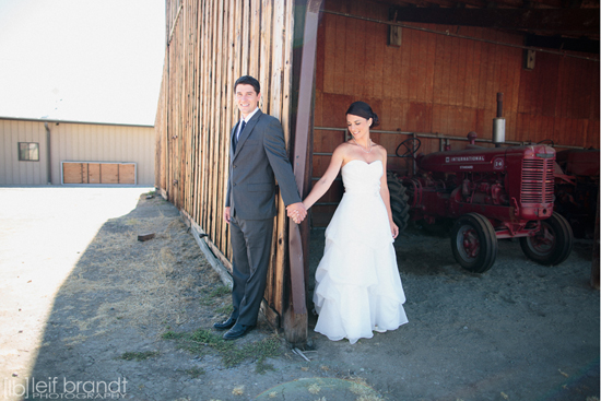 Rustic wedding portrait of bride and groom near barn