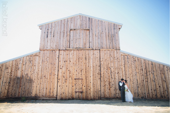 Bride and groom kissing at rustic barn wedding venue