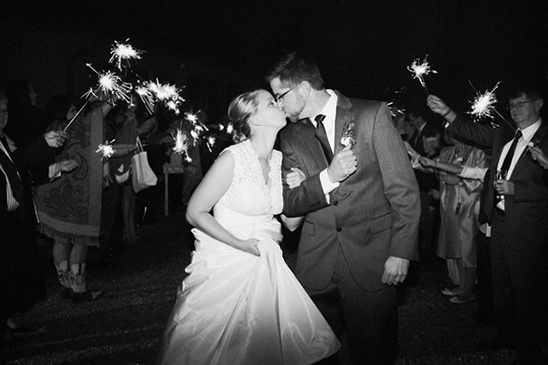 Bride and groom kiss amidst wedding sparklers