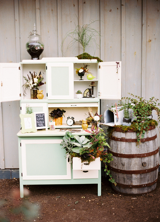 Vintage buffet and barrel with floral decor outdoors