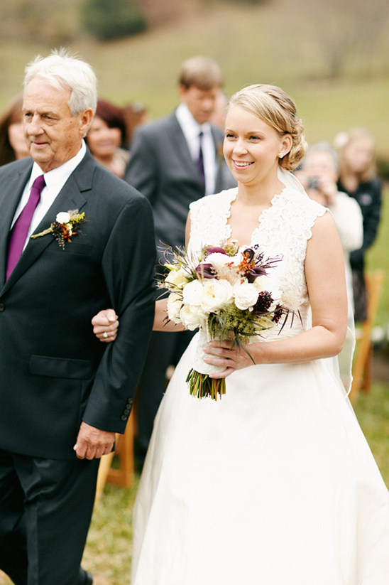 Bride walks with father on wedding day aisle
