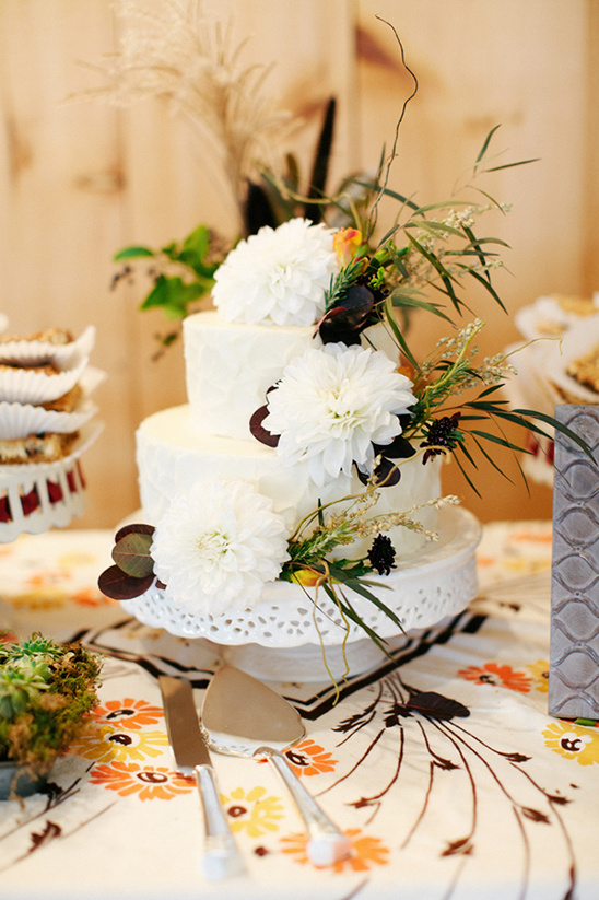 Elegant two-tiered wedding cake with white dahlias