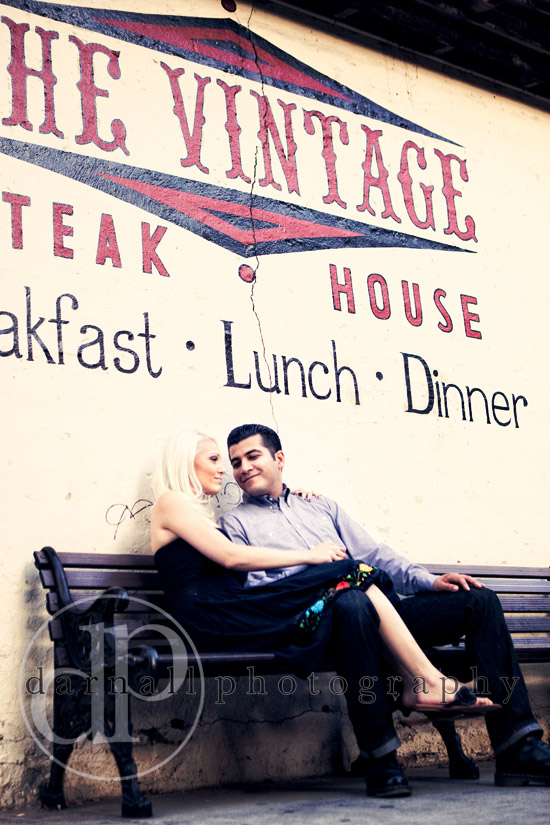 Couple sitting on bench in front of The Vintage Steak House