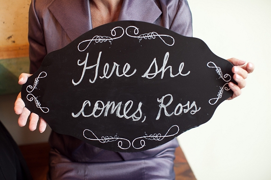 Chalkboard sign Here She Comes Ross wedding photo