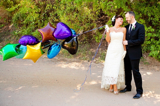 Wedding couple with balloons share a loving look