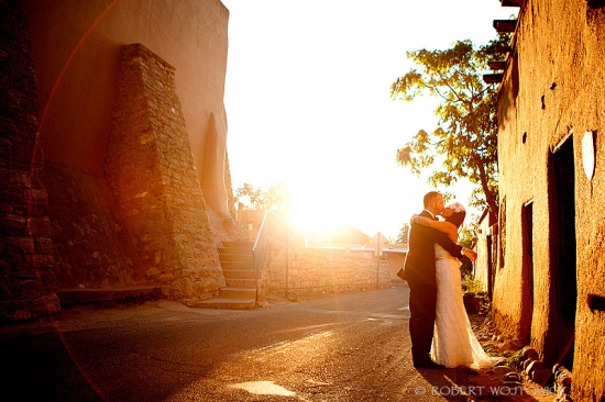 Bride and groom kissing at sunset on their wedding day