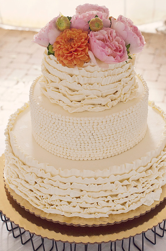 Beautiful tiered wedding cake with ruffles and flowers