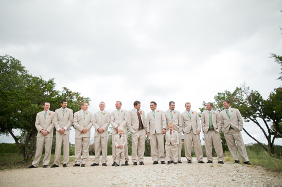 Groomsmen in tan suits at outdoor wedding ceremony