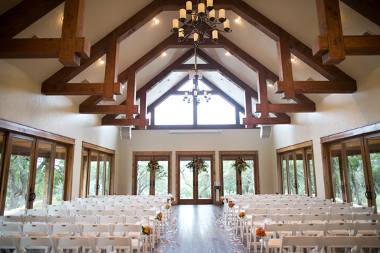 Elegant wedding venue with wooden beams and white chairs