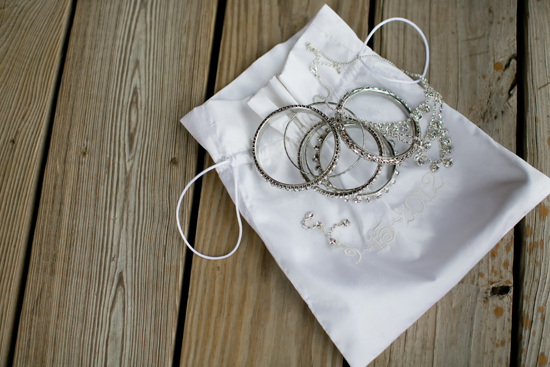 Jewelry in a white bag on a wooden surface