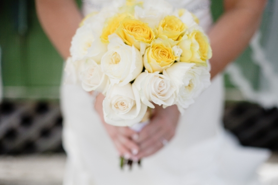 Bride holding yellow and white rose wedding bouquet