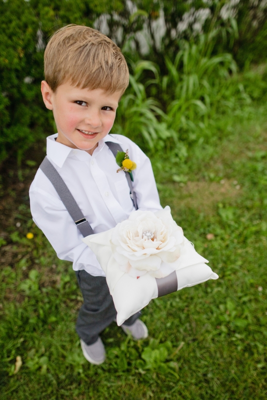 Cute ring bearer boy holding wedding ring pillow