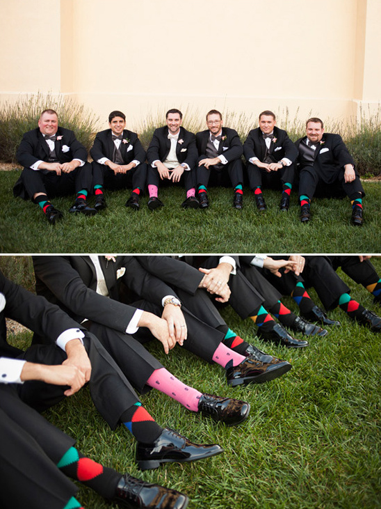 Groomsmen in tuxedos showing off colorful socks