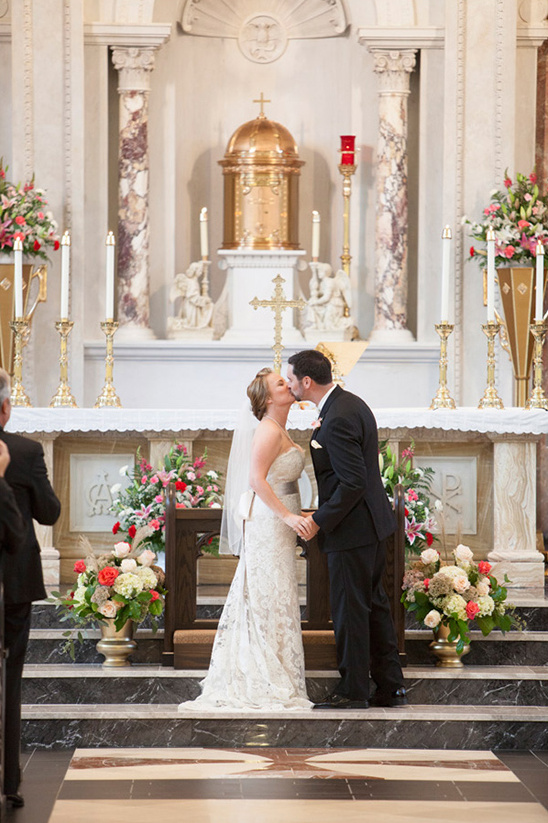 Bride and groom share first kiss at church altar