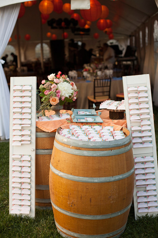 Wedding reception seating cards displayed on barrel table