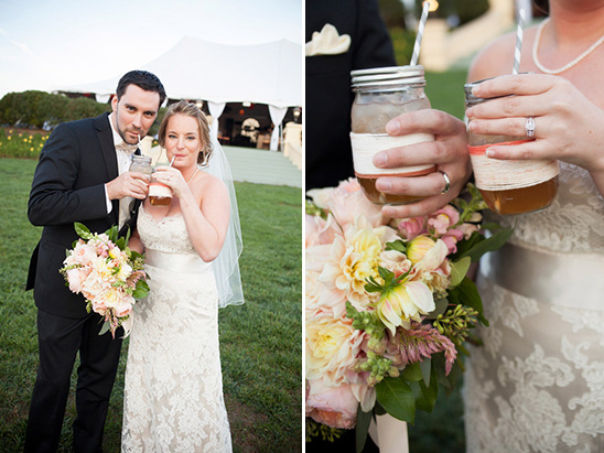 Happy couple toasting with mason jar drinks at wedding