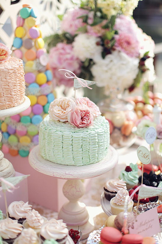 Pastel wedding cake with roses on dessert table