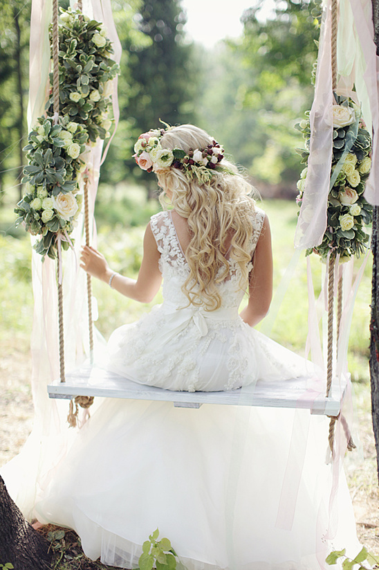 Bride in floral crown on rustic swing