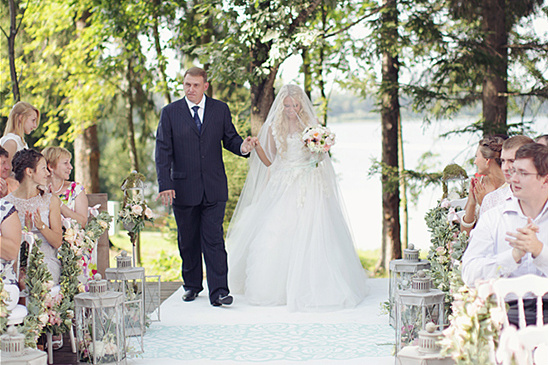 Father walks bride down aisle at outdoor wedding