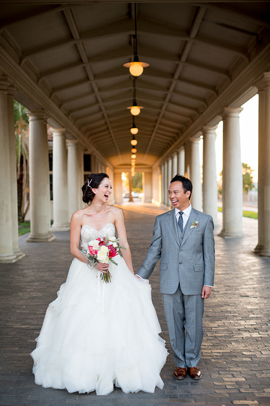 Happy couple laughing on their wedding day, holding hands