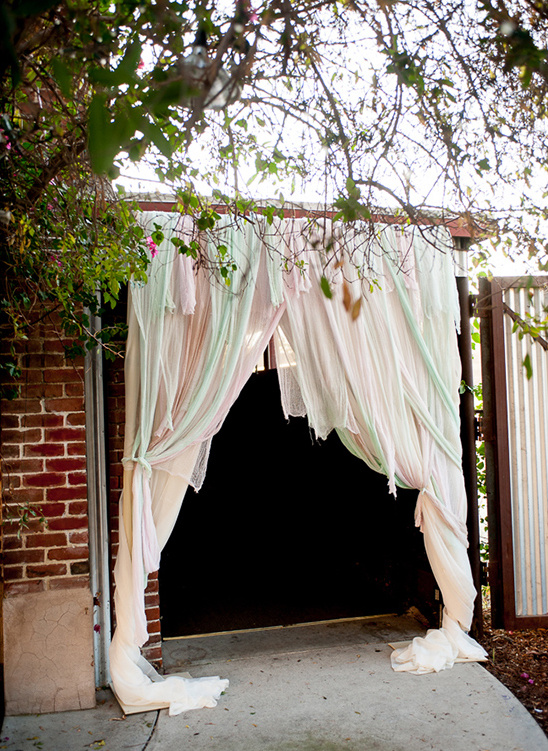 Entrance decorated with fabric curtains and lush greenery