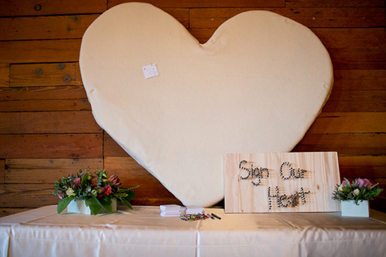 Heart shaped guest sign with flowers and a wooden sign