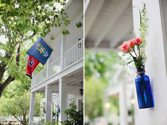 White house with flags and blue bottle flower decor