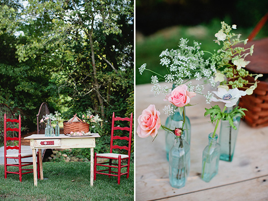 Rustic picnic table with pink flowers in vintage bottles
