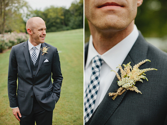 Groom in dark suit, checkered tie, floral boutonniere
