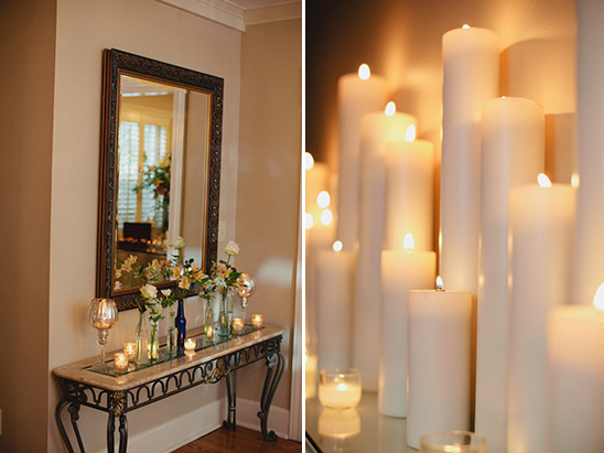 Ornate mirror reflects flowers and candles on console table
