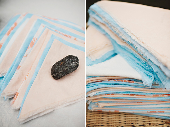 Peach and blue napkins with stone on top of one napkin
