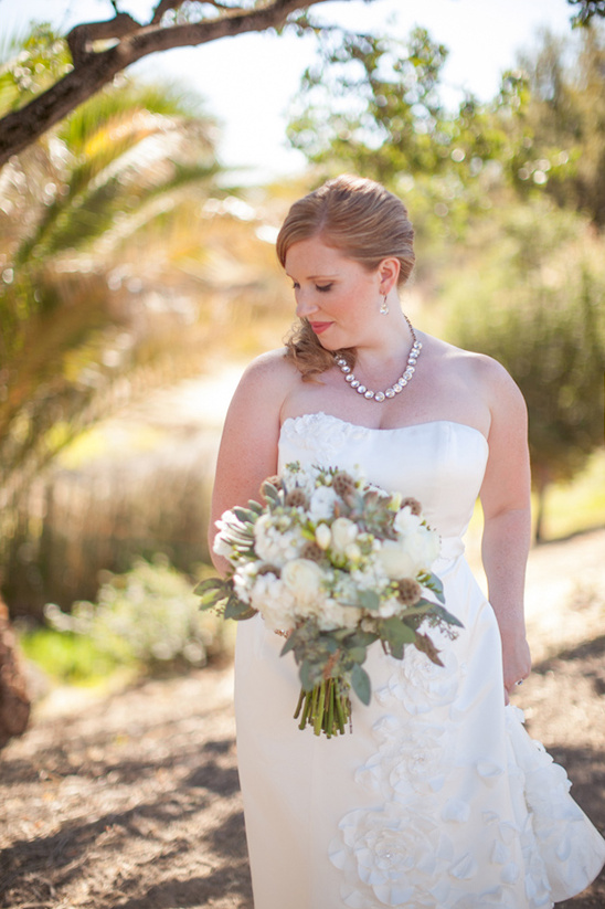 A beautiful bride in a white wedding dress holding a bouquet