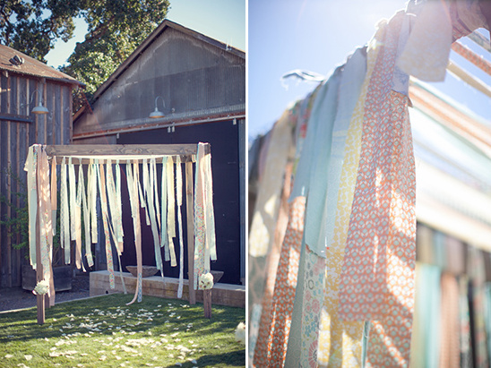 Bohemian wedding arch decorated with colorful fabric ribbons in the sun