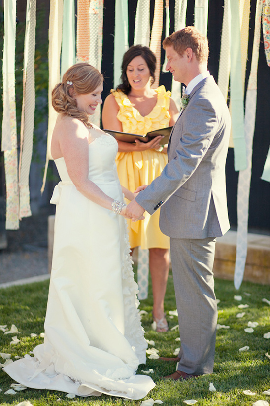 Bride and groom holding hands at wedding ceremony, outdoors