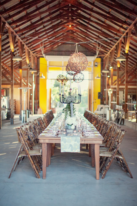 Rustic wedding reception table setting with bamboo chairs and decor