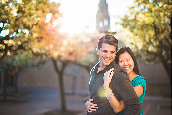 Happy couple embracing outdoors, sunlight shining behind them