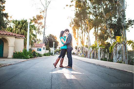 Romantic couple embraces on a road with sunlight in a park