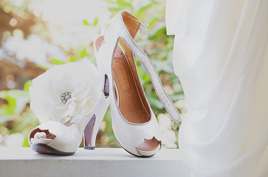 Elegant white wedding shoes with floral details and strap