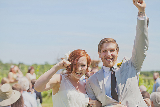 Newlyweds celebrating their wedding joyfully, fist pumping in the air